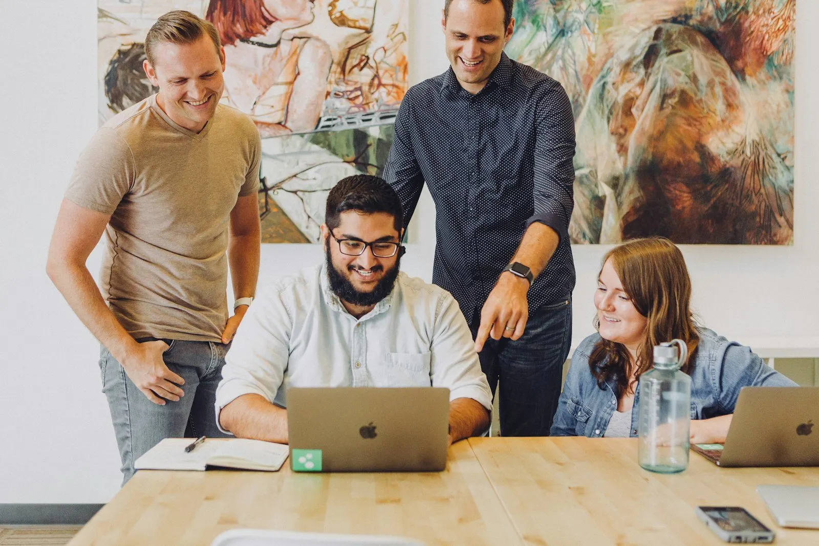 Grupo de personas trabajando juntas alrededor de una computadora